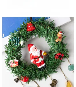 Detail of Christmas wreath with resin Santa, gingerbread man and metal bell pendants