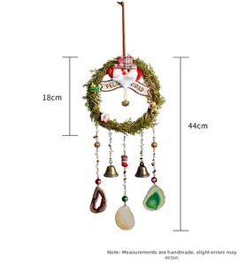 Detailed view of Christmas wall hanging with pine ring, santa, bells and agate slices 44cm