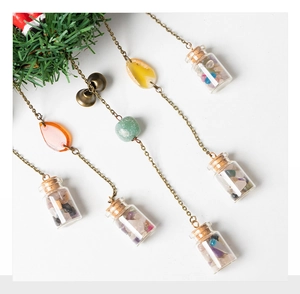 Detail of hanging Christmas wreath with miniature glass bottles and colorful beads decoration
