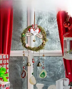 Detail of Christmas wreath with Santa, Feliz Navidad sign, bells and mineral slices