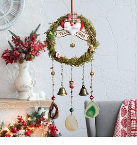 Close-up of Feliz Navidad Christmas wreath with brass bells and colorful agate slices