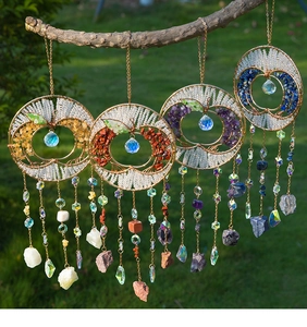 Detailed set of four apple-shaped crystal suncatchers with tree of life stones hanging outdoors