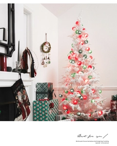 Close-up of colorful cotton ball string lights on a white Christmas tree indoor