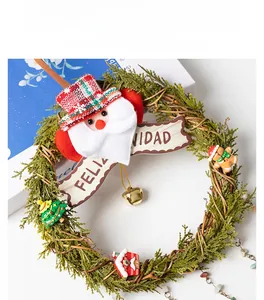 Detail of Christmas wreath with Santa plush, bells and Feliz Navidad wooden greeting sign
