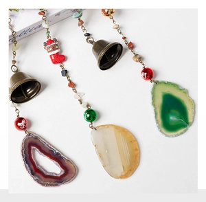 Detail of Christmas natural agate slice hanging decoration with reindeer and small bells