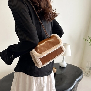 Retro brown leather crossbody bag with white faux fur trim and sleek metal chain strap