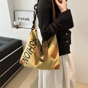 Large khaki canvas tote bag with black FASHION text and leather patches for women