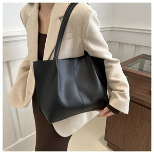 Borsa tote minimalista in pelle PU nera capiente mostrata su modella per l'uso quotidiano