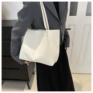 Dettaglio della borsa tote minimalista color crema in ecopelle con spalline sottili fisse