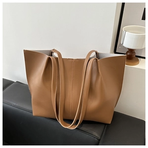 Dettaglio di una borsa tote marrone in pelle PU con cuciture verticali e capienza ampia