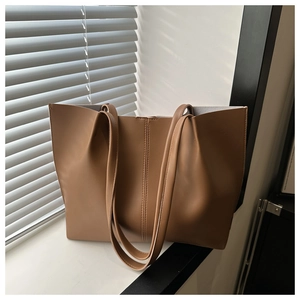 Dettaglio della borsa tote in pelle caramello con doppia cucitura e texture opaca