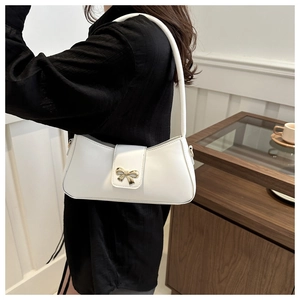 Vue détaillée du sac à bandoulière blanc en demi-lune avec boucle nœud doré