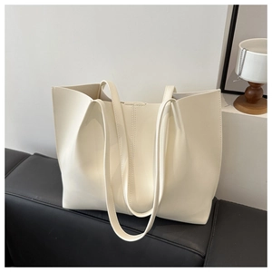 Dettaglio ravvicinato di una borsa tote minimalista bianco crema con cuciture verticali