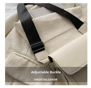Primer plano de la hebilla metálica ajustable gris en la correa del bolso beige chic