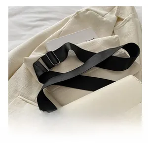Detalle de bolso bandolera blanco crema con correa ajustable de tela ancha de alta calidad