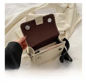 Detalle del bolso bandolera crema con capacidad interior para móvil y tarjetas
