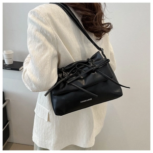 Détail du sac bandoulière en cuir PU noir avec nœud coulissant et lettrage de la marque
