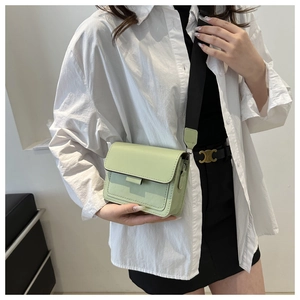 Detalle del bolso rectangular verde menta con costuras y correa de hombro ancha ajustable