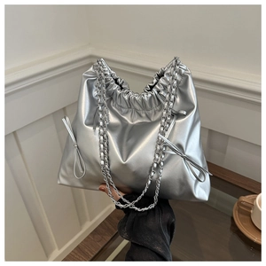 Detail of silver metallic bucket bag with drawstring closure and chain strap