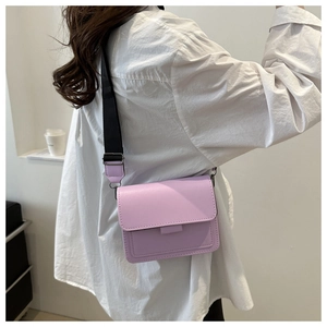 Vista lateral de un bolso cuadrado violeta claro con correa ancha negra en un modelo