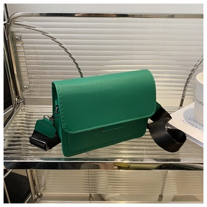 Detalle de bandolera cuadrada verde oscuro con una elegante correa ancha de tejido