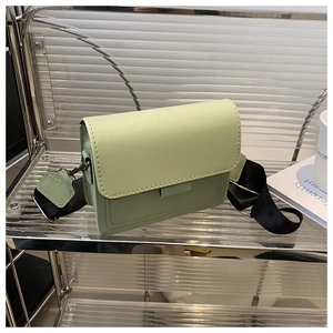 Detalle del bolso cuadrado verde claro con hebilla decorativa y correa ancha de nailon