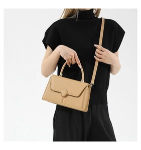 Piccola borsa quadrata kaki chiaro con outfit nero per un look moderno ed elegante
