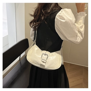 Gros plan sur le sac sous le bras en cuir verni blanc avec boucle argentée décorative