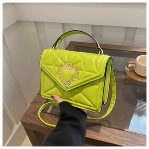 Detail of lime green quilted handbag with gold crown heart buckle and arc handle