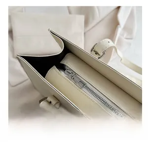 Detail of silver smooth metal zipper and cross-grain leather on beige business tote bag