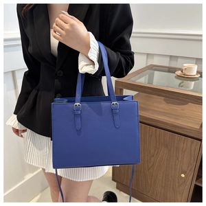 Model wearing a cobalt blue tote bag with adjustable straps for professional office style