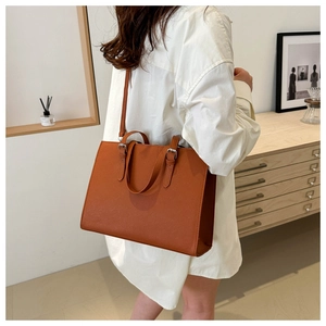 Brown textured leather tote bag with dual handles and long shoulder strap for commuting