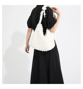 Close-up of white popcorn texture shoulder bag with soft 3D bumps and a side bow detail