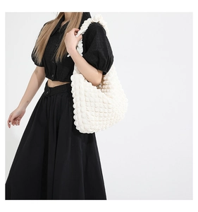 Détail du sac hobo blanc texturé avec le tissu gaufré 3D unique et plis sophistiqués