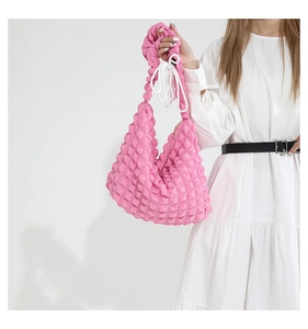 Détail d'un sac cabas rose vif à texture bulles avec cordon et fermeture éclair dorée