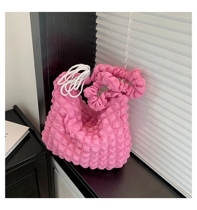 Détails de la texture du sac rose en tissu popcorn avec cordon et surface plissée