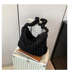 Détail du sac bandoulière croissant noir avec texture gaufrée et tissu plissé