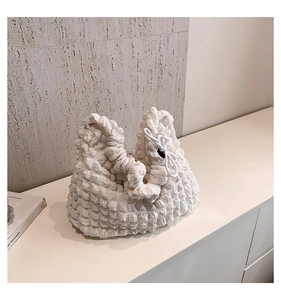 Détail du tissu blanc texturé de ce sac à main minimaliste en forme de nuage