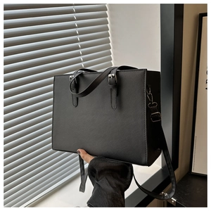 Detail showing the Saffiano texture and adjustable handle of this black tote shoulder bag