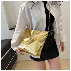 Detail of a vintage golden metallic mirror finish bucket bag with fine chain strap