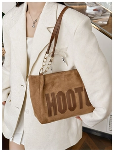 Sac cabas en daim marron avec logo en cuir et bandoulière chaîne sur le mannequin