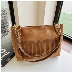 Détail du sac cabas en daim marron avec imprimé HOOTO et bandoulière en chaîne dorée