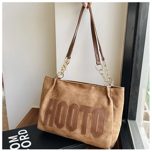 Detailed close-up of brown suede tote bag with HOOTO letter embroidery and gold chain strap
