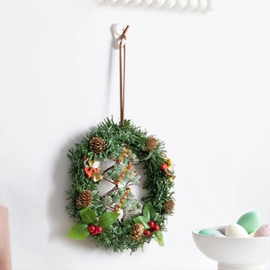 Christmas wreath featuring a wire tree with green stones and festive pine cone accents
