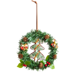 Christmas wreath with green pine needles, red berries and stone-filled tree ornament