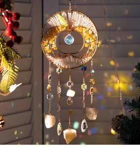 Macro detail of suncatcher with golden tree of life and colorful crystal pendants