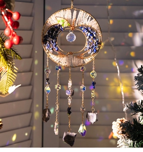 Close-up of bohemian crystal tree of life suncatcher with colorful stones and prism pendants