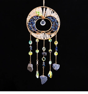 Detail of apple-shaped suncatcher with wire tree of life, colorful stones and crystals