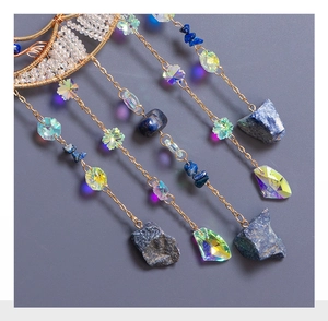 Detail of tree of life suncatcher with colorful crystals and blue raw stone pendant