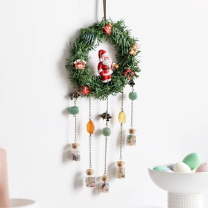 Christmas wreath wall decor with pine needles, Santa doll, and colorful gemstone vials